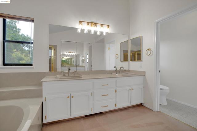 Full bath featuring double vanity and a garden tub