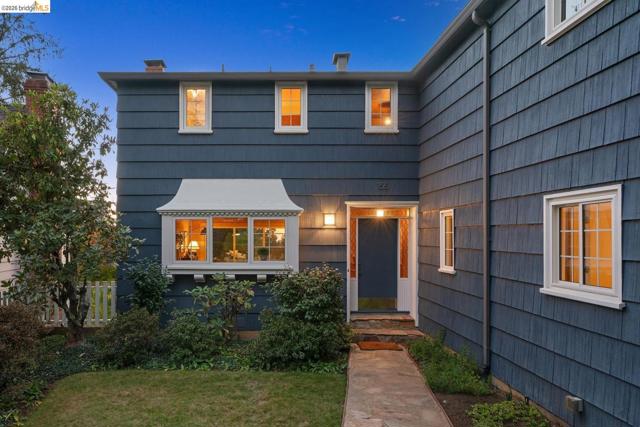 Shingle siding exterior with a prominent bay window featuring decorative trim, a walkway leading to a front entry, and multiple white-framed windows