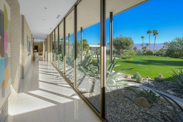 This mid century designed estate is sequestered at the top of a cul-de-sac at Rancho Mirage's guard-gated Thunderbird Heights. The residence exhibits a recently built home that captures the classic vintage vibe while incorporating today's preferred amenities. Views impress in all directions, from incredible valley floor panoramas to a dramatic mountain backdrop. Showcasing a single-level floor plan of approx. 5,601 s.f., the home reveals floor-to-ceiling windows, numerous indoor/outdoor spaces, and terrazzo flooring inside and out. Discover 3 bedrooms and 3.5 baths in the main house, an office, and 2 outdoor guest suites. An entry with skylight and pivoting front door opens to a spacious living room with a fireplace, floating hearth and custom room divider screen. Furnishings provided by a noteworthy Seattle designer are featured in every room, including a family room with walk-in wet bar. The kitchen and dining area displays a double-waterfall island and top appliances. Private grounds encompass a double homesite of nearly 1.3 acres that features a pool, fireplace, built-in BBQ, expansive lawns, enchanting gardens, pool bath, yoga platform and a meditation garden just outside the primary bedroom. Architecture by Stuart Silk, landscape by Anne Attinger.