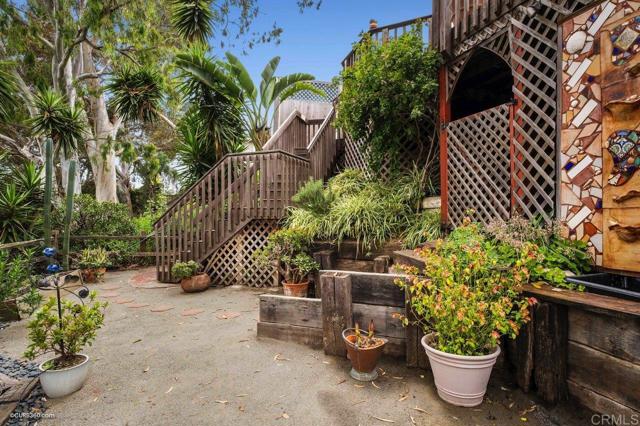 The deck staircase leads to the lower terrace with canyon access