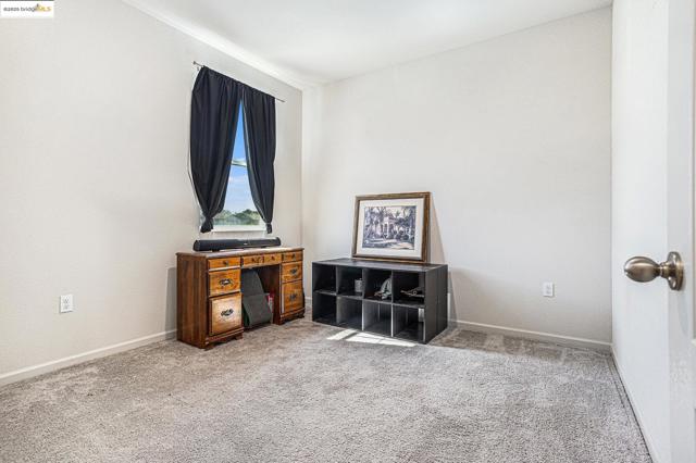 Unfurnished room featuring light carpet and baseboards