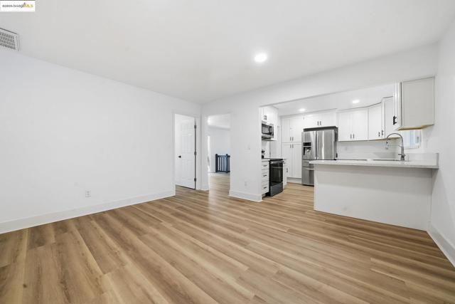 Unfurnished living room with light wood finished floors and recessed lighting