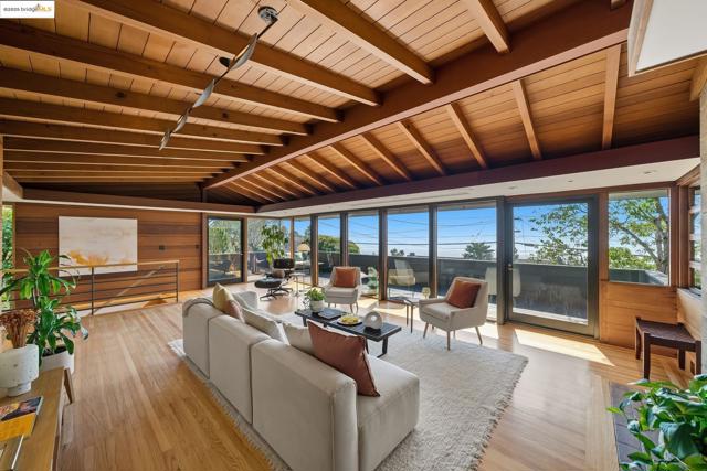 Living room featuring light wood-style floors, wooden walls, and wood ceiling