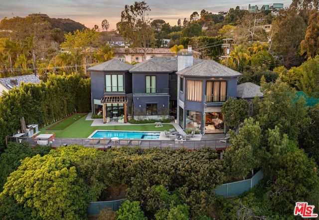 Impeccable Modern Ocean View home in Brentwood. Perched along lower Westridge Road just seconds from Sunset Boulevard, this stunning residence offers incredible light, privacy and expansive views of the Los Angeles coast & Catalina. The home combines various elements of traditional design with modern finishes including art gallery walls, large windows,12-foot ceilings, and a perfect indoor-outdoor flow for comfortable living or vibrant entertaining. The front door opens into a double-height chandelier foyer which leads to a bar area complete with seating and a Sub-Zero wine cooler. Beyond the entryway lies the sensational living room with floor-to-ceiling glass which opens to the resort-style backyard and panoramic views. The sleek modern kitchen is built around a huge L-shaped island with a waterfall breakfast bar, top-of-the-line Wolf appliances, and French doors that open to a fountain garden patio with seating. The primary suite is complete with incredible ocean views, a fireplace, spacious bath with dual vanities, and a large boutique-style walk-in closet. The property is private and gated, ensuring the utmost security. Come enjoy this expression of warm functional design. A prime location near hiking trails, schools, and parks, just moments to beaches, freeways, and the wonderful fine dining and shopping options of Brentwood, Santa Monica, and the Westside.