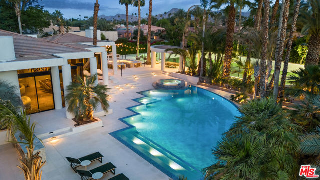 Designed by Narendra Patel, a protege of Donald Wexler, and transformed by a meticulous $2.5 million renovation, this 2.4-acre estate in Rancho Mirage's exclusive Clancy Lane enclave is a true architectural masterpiece. Set on two expansive lots with the potential to increase its square footage, the property offers both immediate luxury and future possibilities. Spanning 8,800 square feet, it includes a main residence and two detached guest houses, offering a total of seven bedrooms and nine bathrooms. Every detail of the renovation was thoughtfully executed, from new travertine flooring and state-of-the-art HVAC systems to a cutting-edge security network with 24 cameras. The interiors boast soaring vaulted ceilings and floor-to-ceiling glass, filling the home with natural light. The great roomwhere Sonny Bono received Gerald Ford's endorsementfeatures a sleek wet bar, while the chef's kitchen is equipped with top-tier appliances and a massive island.Steeped in history, this estate has hosted U.S. Presidents, celebrities, and dignitaries. The outdoor space is equally spectacular, featuring a fully reimagined zero-edge infinity pool framed by Turkish white limestone. Adjacent to the 18-seat sunken Hibachi bar, a 450-square-foot outdoor kitchen includes a Forno Piombo wood-fired pizza oven, smoker, fryer, and more.Additional highlights include a professional tennis court, tranquil koi ponds, and a hidden 5,000-bottle wine cellar with a private dining room. It is ideally located less than five minutes from El Paseo's designer boutiques  Louis Vuitton, Tiffany, Gucci, Bottega Veneta, Apple, and the desert's finest restaurants. A sanctuary of modern luxury and timeless elegance, this estate is a masterful blend of architectural brilliance, resort-style amenities, and storied history.