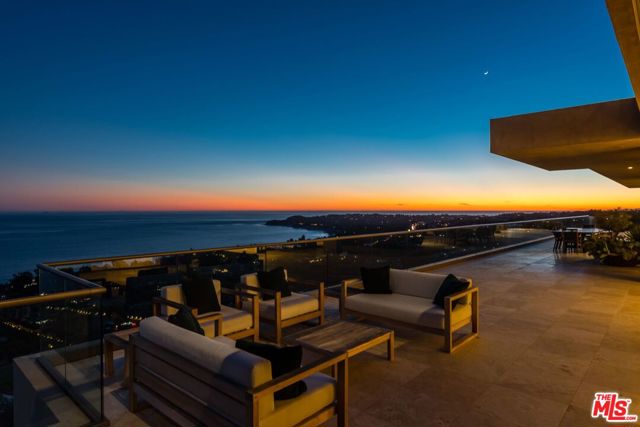 Set on approx. 15.5 acres in Malibu at the top of Winding Way, this contemporary masterpiece by architect Michael E. Barsocchini offers panoramic ocean views from Palos Verdes to Point Mugu. A double height entry welcomes you to a stunning great room featuring a fireplace, disappearing glass walls, travertine floors & an open floor plan with gorgeous views throughout. The living, dining, kitchen & media rooms all open, via wide glass doorways, onto the deck that stretches the length of the home. A floating walkway leads to the primary wing featuring a spacious suite with fireplace, luxury bath, exercise/yoga room, custom closet, office & private deck overlooking the Pacific. Three additional en-suite bedrooms with ocean views. A beautifully landscaped lawn sits beside the infinity pool, spa & BBQ area. Just beyond the pool trails leading to add'l acreage above the house allowing you to reconnect with nature. Enjoy incredible sunsets from this designer home set in the hills of Malibu.