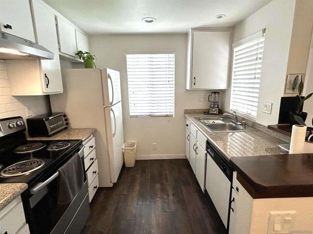 Open kitchen. Electric stove, refrigerator, granite countertops.