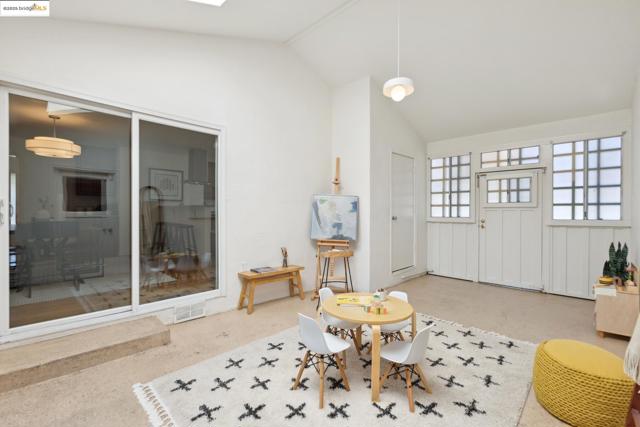 Living area featuring speckle patterned floor, a skylight, and high vaulted ceiling