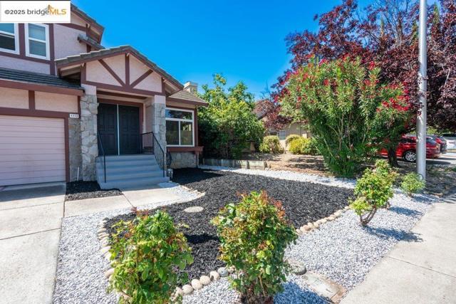 View of exterior entry with stone siding, stucco siding, and a garage