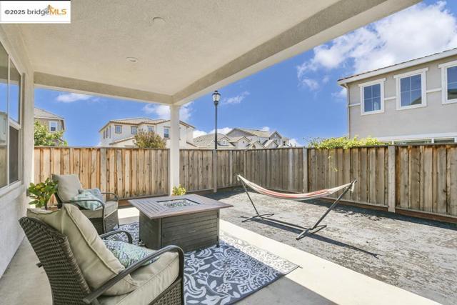 Fenced backyard with a patio and an outdoor living space with a fire pit