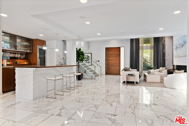 613 N Alpine Drive Beverly Hills, California Modern luxury in picturesque & coveted BH Flats! Superbly maintained, thoughtfully redesigned w/ generous floor plan, manicured landscaping w/ fruit trees & vegetable plants, high end designer finishes. Skylighted double-height entry to living room, wet bar, gym, expansive family room, office equipped w/ bath & en-suite guest bed w/ access to outdoor patio. Kitchen customized w/ German cabinetry, Miele & Viking appliances, island w/ seating in addition to dining area. Upstairs: a primary suite, a jr. suite, 2 en-suite beds, multi-purpose loft w/ wet bar & under counter fridge. The suites open to expansive outdoor deck. Ample walk-in closets & custom marbled bath w/ double shower, spa tub w/ jets, bidet & laundry shoot. Covered backyard patio w/ more lounge areas, including trellised dining w/ fireplace, BBQ counter stools, & pool chaises. 515 SF pool house w/ full kitchen, bath, outdoor shower, powder & locker room. Countless form & function details at this entertainer's dream!
