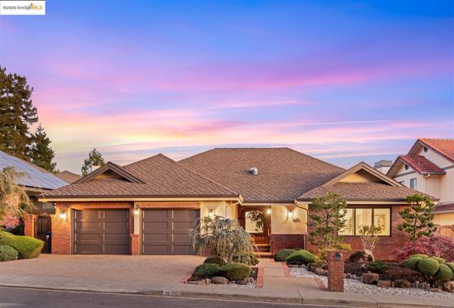 View of front of home with brick siding, decorative driveway, an attached garage, and a shingled roof