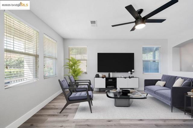 Living area with wood finished floors and a ceiling fan