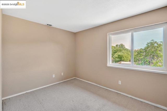 Empty room with carpet and baseboards