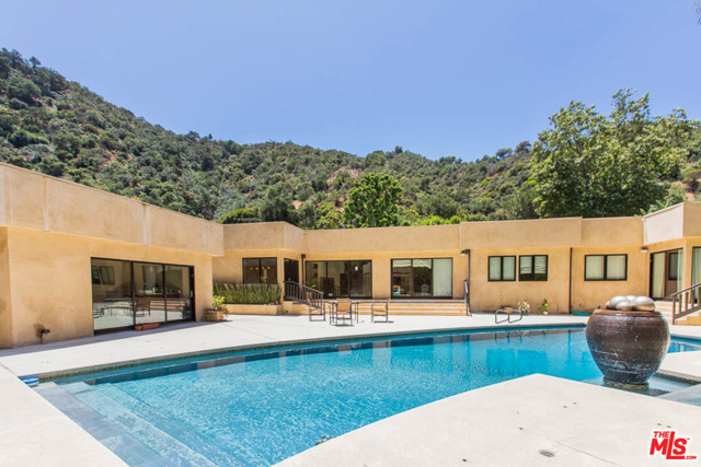 1634 Benedict Canyon Drive Beverly Hills, California Truly one-of-a-kind & impressive contemporary one-story home in one of L.A.s most prestigious neighborhoods. Extensively remodeled, this stunning Beverly Hills home features sophisticated indoor/outdoor living spaces; state of the art kitchen with limestone countertops and top-of-the-line appliances, custom cabinetry, 1100-bottle wine room; 2 master bedroom suites with large walk-in closets, office/den/media room; a detached guest unit that could be used as a pool house for entertainment; extra-large lap pool; gorgeous gazebo and low maintenance backyard; designer lighting and finishes throughout the home, distressed walnut floors, double-paned windows, copper plumbing, Nest thermostat, newer HVAC, air ducts and water heater. The open floor plan and the dreamy outdoor space makes this property ideal for gatherings and events. This property is a true retreat.
