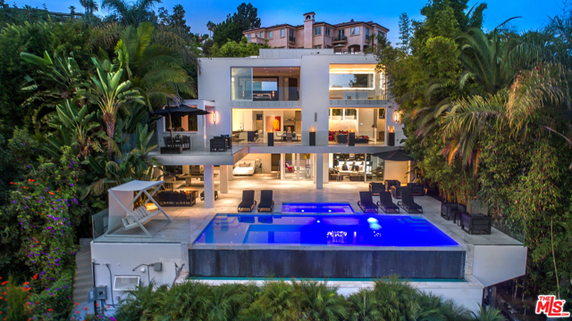 9066 St Ives Drive Los Angeles, California Major price deduction by the millions! This reimagined Modern Masterpiece, meticulously curated from the Owner's distinct vision, sits minutes above the iconic Sunset Strip and offers unobstructed city views. Immaculately finished with every detail accounted for on a sophisticated level of custom craft by world-renowned Architect, Paul McClean, the estate offers luxury lined living, dramatic architecture, soaring ceilings, a two-story living room w/ fireplace adjacent to a forming dining area, incredible marble chefs kitchen designed by SCIC, and an entire level of its own dedicated to the Presidential Master Suite. The lower level features two en-suites, home theater, wine cellar, bar, and a free-flowing living area that seamlessly expands to the backyard sanctuary. A sparkling infinity pool/spa, lounge area, BBQ, billiards, and bonus outdoor gym makes this estate an Entertainer's delight, equipped with the finest appointments. PLEASE SUBMIT ALL OFFERS BY 6:00 PM on 10/30/2020.