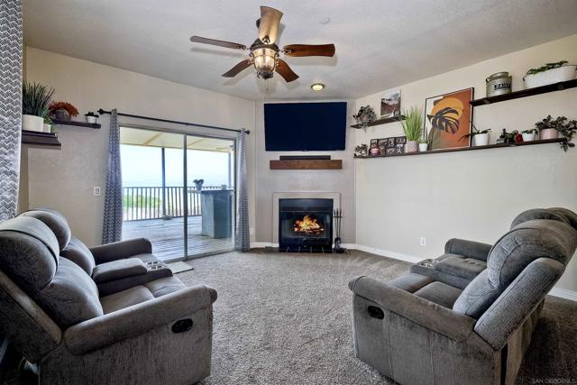 Fireplace in living room of 2nd home. Sliding glass doors lead to large covered patio.