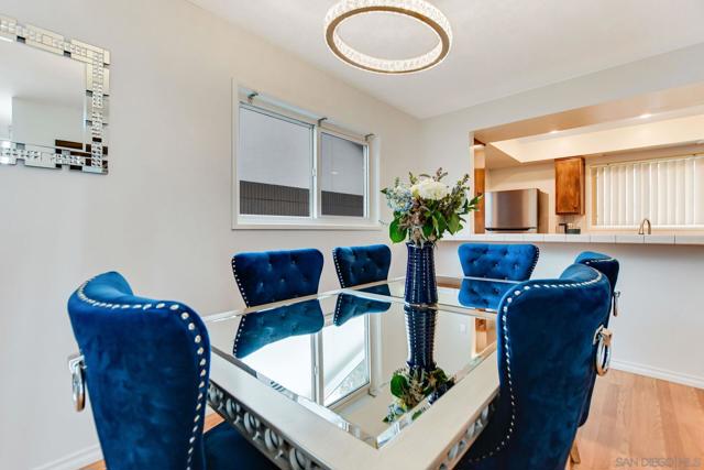 open floor plan allows for a full dining room table and chairs setup.  The kitchen serving island and kitchen is featured in the background.