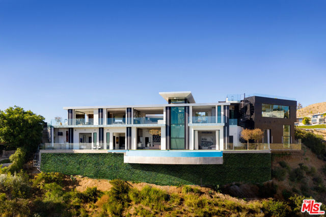 1622 Viewmont Drive Los Angeles, California Significant Price Reduction: Experience the ultimate in luxurious California living from this newly priced, immaculate Hollywood Hills contemporary masterpiece perched above the famed Sunset Strip with breathtaking jetliner views. Tucked away from the city, the residence sits at the end of a private, gated street and is enveloped by spectacular vistas from DTLA to the Pacific. The entry is itself a geometric statement piece with modern, cubic columns illuminated and framing the cityscape in the distance. With a sweeping open floor plan and endless indoor/outdoor flow, the compound is a true entertainer's paradise. Each space is beautifully accented by balconies and disappearing walls of glass allowing for you to enjoy the mesmerizing vistas from nearly every room. The kitchen is appointed with sleek, glossy cabinetry, built-in top-of-the-line appliances, Italian granite backsplash, and double islands. Rivaling the most luxurious five-star resorts, the sumptuous primary suite includes a dramatic two-story dressing room and decadent bath with soaking tub, dual showers, and makeup vanity. Additional amenities include library, high-end fitness studio, media room, well-appointed guest suites, three-car showcase garage, and so much more. Relish the beautiful California weather in the outdoor spaces which boast a sparkling infinity-edge pool, sprawling grassy knolls, al-fresco dining areas, and a rooftop sky lounge with an amazing panoramic view. A work of art in a world-class locale, this gorgeous Hollywood oasis is secluded, yet just moments to the iconic Sunset Strip and prestigious Beverly Hills.
