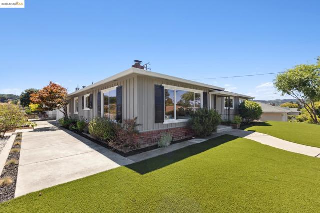 View of front of home featuring board and batten siding, brick siding, a chimney, and a front lawn