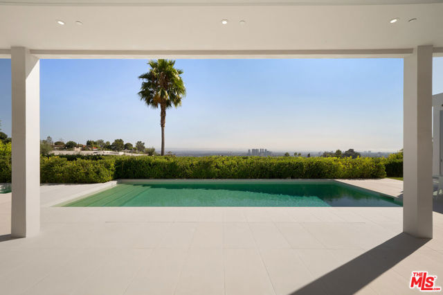 1115 Wallace Beverly Hills, California One of the most sophisticated design homes currently available. Rebuilt in 2016, this trophy property offers a classic Modern architecture that makes an unparalleled statement of vision & design while showcasing stunning panoramic city to ocean views. The property has apx. 28,000 sq.ft. lot on a private cul-de-sac in prime Trousdale Estates, completely private, gated, & hedged. The house is flawlessly designed & crafted, apx. 12'6" ceilings, floor-to-ceiling windows/ doors seamlessly integrate interior & exterior spaces for the ultimate California lifestyle. Stunning paneled entrance gallery with floor-to-ceiling doors perfected by elegant courtyard fountain. Spacious living room w/fireplace & sunken bar. Den, formal dining room, & family room w/fireplace & adjoining chef's kitchen w/island & Miele appliances. Three guest bedroom suites & master suite w/custom walk-in closet & luxurious bath. The open outdoor space offers covered & open patios with pool & spa, all overlooking the incredible views
