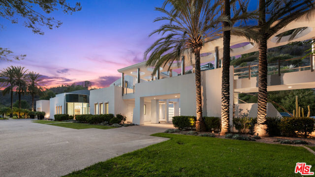 A brilliant, modern achievement situated behind the ultra exclusive gates of Beverly Park North. A flawless contemporary by Richard Landry commissioned by mathematician and entrepreneur Norman Zada, this 20,000 SF compound on an exceptional 6.78-acre lot features a secure compound with an approximately 6,100 SF multi-level guest residence and entertainment pavilion connected to the main house by a futuristic steel-columned bridge. The grounds include a lap pool and pool house, large pool gazebo, separate plunge pool, paddle tennis court, security pavilion, cascading waterfalls and so much more.