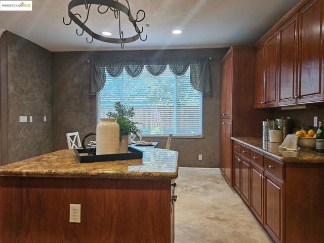 Kitchen featuring dark stone counters and recessed lighting