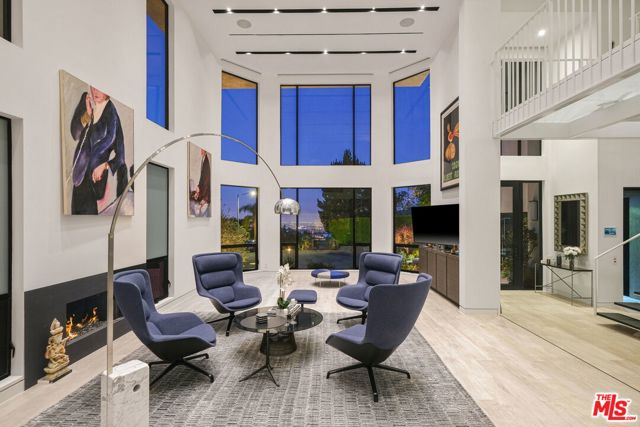 1463 Floresta Place Pacific Palisades, California Impeccably designed by award-winning architect Michele Saee, this ultra-contemporary smart home rests upon a rare 2.27-acre parcel of land at the top of a cul-de-sac in Pacific Palisades with expansive hillside and city views. Showcasing functional living spaces and a fresh art gallery-style design, the home is replete with light porcelain floors and walls of energy-efficient windows that fill each space with incredible natural light. Through the foyer, the great room instantly captivates with two-story ceilings, flowing seamlessly into a flex living space and dining area with a 2,200-bottle wine cellar. Also on the main level is the gourmet kitchen, complete with custom Italian lacquered cabinetry, Gaggeneau appliances and a 16' island with quartz counters. The home features four en suite bedrooms, including the luxe primary suite with 20' closet, resort-like bath with Toto Neorest and tranquil balcony, and comes fully equipped with a Crestron system, solar panels, backup 22 kW Generac generator, elevator, and 2-car garage with epoxy floor. Just outside lies a lush hillside oasis with a built-in BBQ, lounge areas, fruit trees, vegetable garden, firepit, and pool and spa for ultimate relaxation and entertainment. Contemporary in design yet comfortable by nature, this home sets an entirely new benchmark for future-thinking design in Pacific Palisades.