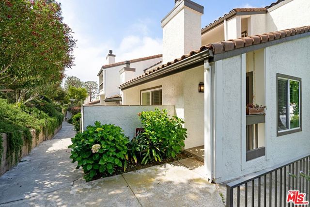 1728 Palisades Drive Pacific Palisades, California END UNIT townhouse is move-in ready, private and, because of the abundance of windows, filled with natural light. Beautiful hardwood floors throughout, enter into a spacious living room with wood-burning fireplace that spills out to a lush patio perfect for outdoor grilling & dining. The eat-in kitchen with mountain views has been recently remodeled and features Quartz counters, custom cabinets, stainless steel appliances & recessed lighting. A formal dining room with built-ins, a spacious bedroom with mountain views and a remodeled bath complete the downstairs. Upstairs is the primary suite with high ceilings, a large balcony, and a well layed out bathroom. There is also a 'bonus room' perfect for the home office. Plantation shutters, new dual-paned windows & sliders, dedicated laundry room, two car garage with direct entry, central heat & air & more! Classy & hip pool, spa, sauna, gym and two tennis courts. Enjoy resort-like living surrounded by nature and so close to the beach and quant village of Palisades.
