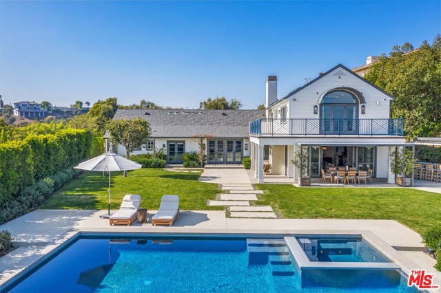 1126 Stradella Road Los Angeles, California Privately secured behind a gated motor court entry and perched on 1.5+ acres atop one of Bel Air's most coveted streets, this serene haven offers sweeping views of downtown, ridge tops, canyons across to the Pacific Ocean. Completed in 2016, The Himes Miller Group reinterpreted this traditional Hampton-style residence with a progressive approach. The main level presents European hand-scraped white oak floors, a private study, formal sitting area, and 3 ensuite bedrooms. Top level primary quarters features wrap-around terrace with unobstructed mountaintop and ocean vistas, and a fully equipped gym and yoga studio for a focus on health, fitness and recovery. An open kitchen couples with the warm and cozy main entertainment room exhibiting reclaimed wood beams and indoor/outdoor fireplace. Abundant flat grassy land, outdoor bar, sunken fire pit, drop-edge pool and jacuzzi with ozone water system, horseshoe court, gardens & fruit trees. A Custom design to reflect comfortable luxury.