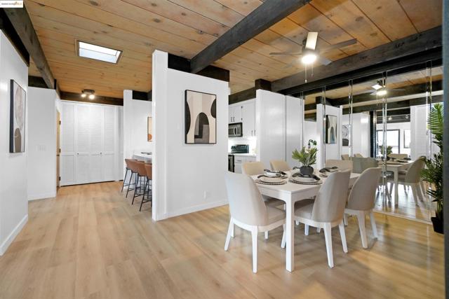 Dining space featuring a wood ceiling with exposed beams, a ceiling fan, and light wood-style flooring