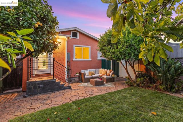 Back of house at dusk with an outdoor hangout area, a patio area, and stucco siding