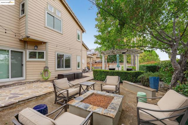 View of patio featuring a pergola and an outdoor living space with a fire pit