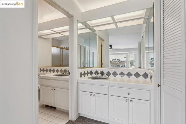 Full bathroom featuring vanity, decorative backsplash, tile patterned flooring, and ceiling fan