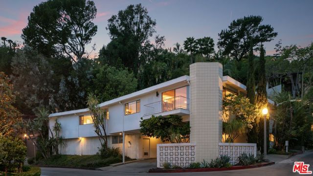 Beautifully authentic, bright Mid-Century Modern in Beverly Hills w/a spacious open floor plan, 4 beds, 3 baths & large backyard surrounded by mature greens. The expansive carport leads into the lower portion of the residence, with one bed & ensuite bath. Flooded with natural light, the main level opens up into the living & dining room w/spectacular Mid-Century detailing and large picture windows with treetop views. The generous home also includes an office/library, laundry room, balcony & stone living room fireplace. The spacious primary suite features a floor-to-ceiling marble fireplace, 2 walk-in closets, a dual vanity bathroom with tub/shower & direct access to the backyard. Find a wonderful sense of peace & privacy outdoors around the swimming pool with waterfall feature & ample space for entertaining/lounge. Perfect for developer or owner user w/easy remodeling capability. Within a top school district & close proximity to Golden Triangle/Sunset Strip shopping, dining & nightlife.
