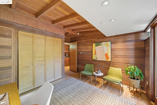 Sitting room with recessed lighting, wood walls, wood finished floors, and a wooden ceiling with exposed beams