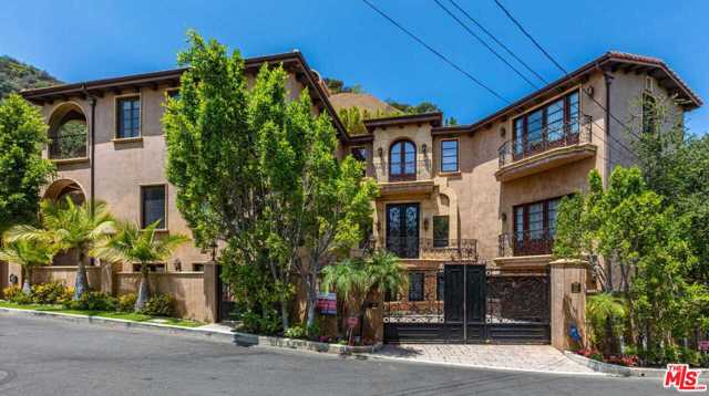 9821 Beeson Drive Beverly Hills, California Gates Beverly Hills estate on a private cul de sac. This gracious and elegant, five-bedroom, seven-bathroom estate boasts a grand entry with a curved staircase leading to three ensuite bedrooms and an impressive master suite with a romantic balcony and a sunny bathroom with spa tub. The entry showcases an incredible volume, scale, high ceiling, a formal living, and dining, gourmet chef's kitchen, and huge pantry, breakfast room, spacious family room, and a fireplace. French doors leading to resort-like pool and spa. On the lower level, there is a fifth ensuite bedroom and media room perfect entertaining. The hillside is a paradise of privacy with mountain and city views, terraced patios, fountains, and a courtyard for entertaining, two-car garage, and ample parking. The main level with Mahagony wood floors consists of formal living and dining a gourmet chef's kitchen with a generous center island.
