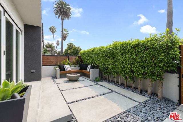 409 Grand Boulevard Venice, California Situated on a corner lot, this gorgeous, renovated, gated Venice home exudes modern mid-century charm! Completely remodeled inside and out, featuring three bedrooms, four baths + office. This property includes unique touches such as French white oak floors, a Bateig Blue Limestone fireplace, accordion glass doors to the patio, and a bonus office space. Savor the home's indoor/outdoor flow by relaxing or entertaining on the lush private patio oasis or taking in the ocean views on the expansive rooftop terrace. Enjoy ensuite spa-like baths with beautiful counters and custom fixtures in each of the bedrooms. The sun-soaked kitchen has abundant storage, high-end appliances, island space, and an in-room dining area. Steps from Abbot Kinney, where you will find the best restaurants and shops LA has to offer, and three blocks from the ocean, this home comes complete with a large two-car garage.