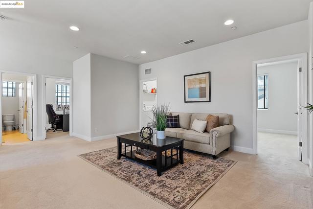 Living room featuring light carpet, an office area, and recessed lighting