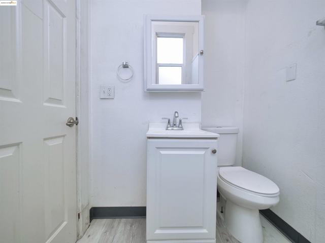 Half bath with vanity and light wood-style floors