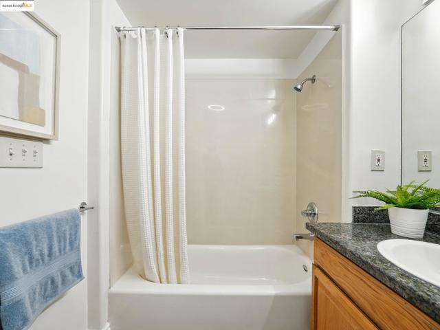 Bathroom with shower / bathtub combination with curtain and vanity