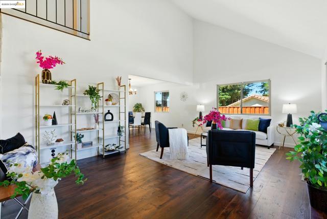 Living area featuring high vaulted ceiling, hardwood / wood-style floors, and a chandelier