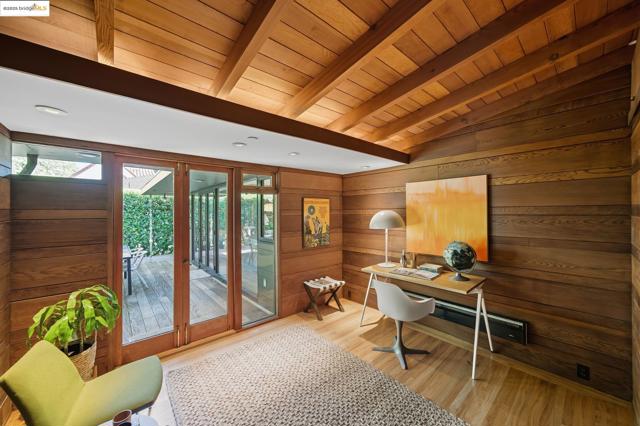 Home office with wood finished floors, wooden ceiling, and wood walls