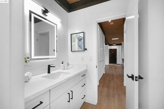 Bathroom with wood ceiling, vanity, and light wood-type flooring