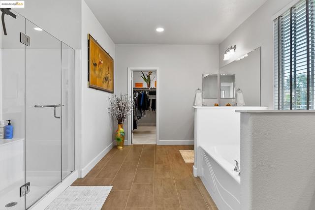 Bathroom featuring a stall shower, a garden tub, and recessed lighting