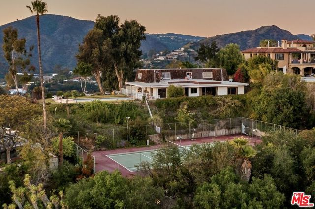 A magnificent lower Bel Air tennis court view estate offering a rare opportunity to build something truly remarkable. This unique parcel has 36,000 SF of mostly flat grade with A+ panoramic view spanning from Downtown LA to the Pacific ocean, Catalina island, and the Getty with an expansive 170 ft frontage. The property sits above street grade with good setback allowing complete privacy. Ideal lot for either a developer or an owner user looking to build their dream house! Enjoy CA Sunsets or DTLA skyline from the comfort of your home! Priced for land value as a development opportunity.
