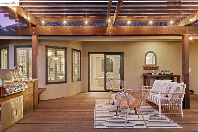 Wooden deck featuring a grill and a pergola