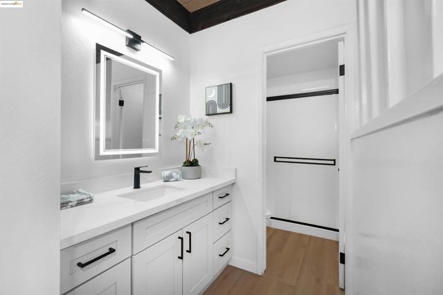 Full bathroom featuring vanity, a shower stall, and light wood finished floors
