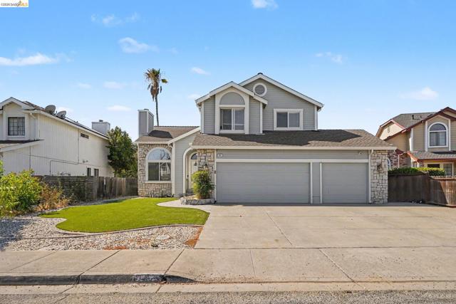 Multi-level exterior featuring stone veneer accents, lap siding, two-car garage, and a concrete driveway