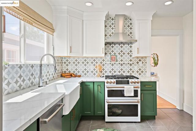 Kitchen with green cabinetry, white cabinetry, double oven range, wall chimney exhaust hood, and recessed lighting